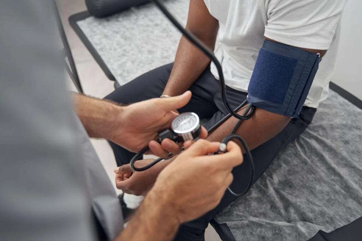 Healthcare professional measuring blood pressure during a DOT physical exam