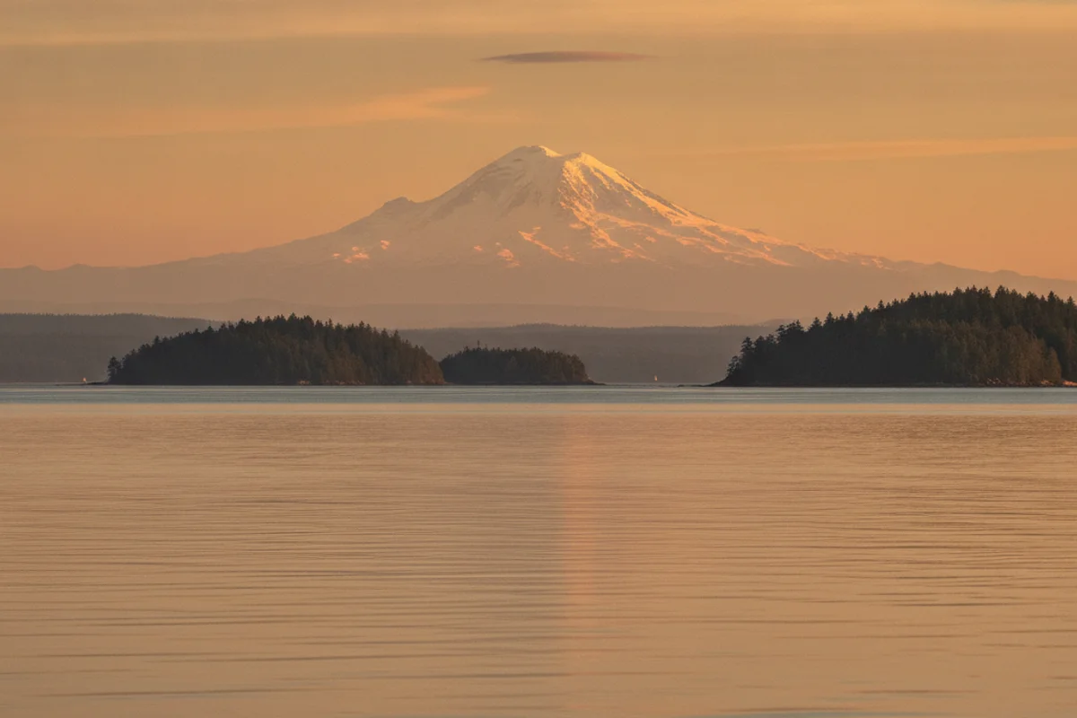 A sweeping Washington landscape with Puget Sound water, evergreen islands, and Mount Rainier in the distance